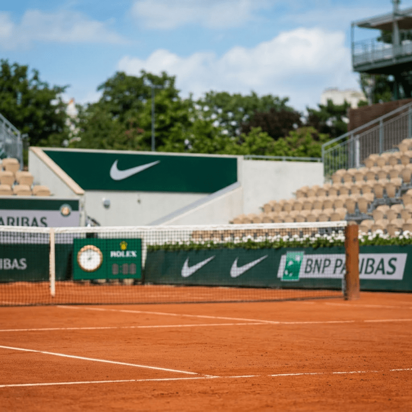Female tennis player striking ball with forehand on clay court
